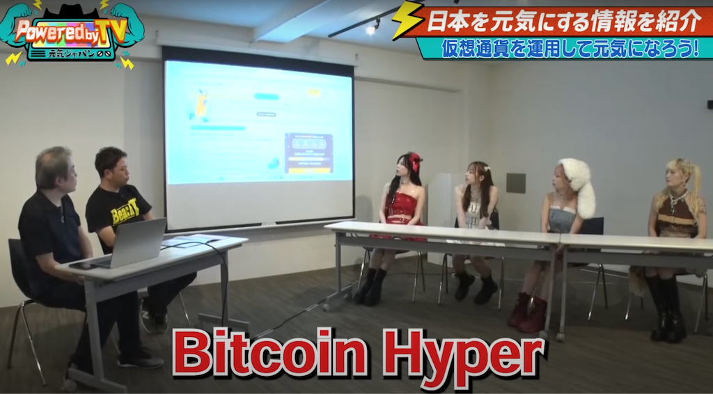 会議室でスクリーンに映されたBitcoin Hyperのプレゼンを見つめる出演者たち。Powered by TVの番組内で仮想通貨を紹介